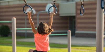 Child playing on monkey bars.