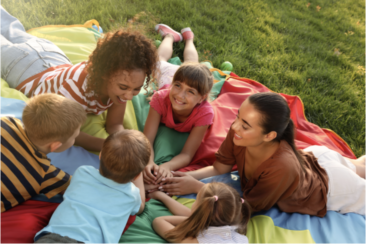 Children laying on a parachute.