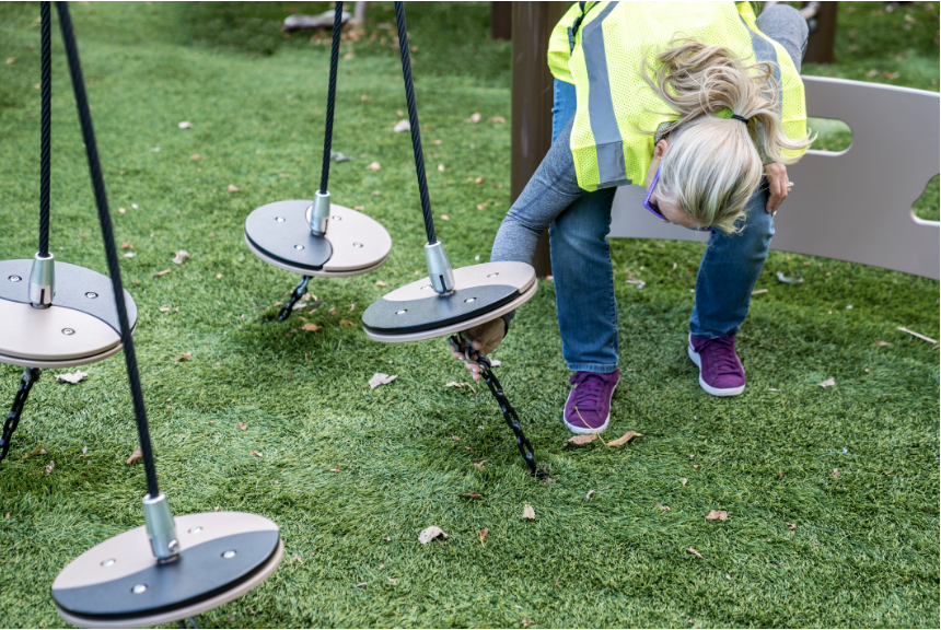 Playground inspector inspecting swings.
